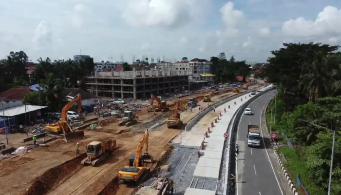 Aktivitas proyek pelebaran jalan di wilayah Bogor dengan pekerja dan rambu konstruksi